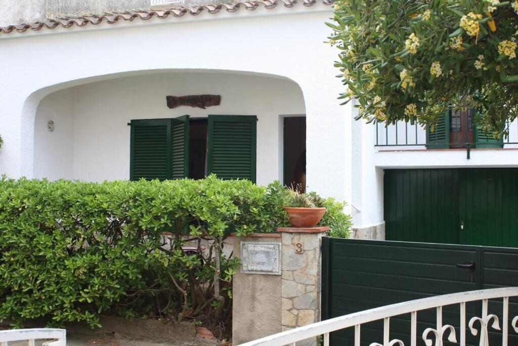 une maison blanche avec des volets verts et une clôture dans l'établissement La Gavina, à L'Estartit