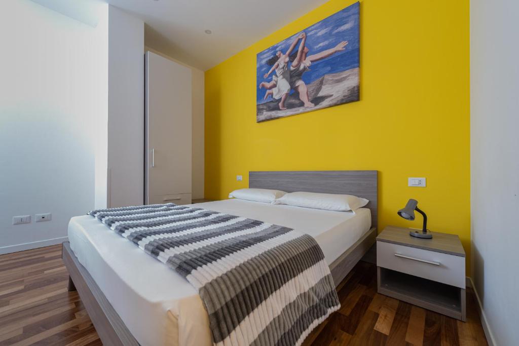 sypialnia z łóżkiem i żółtą ścianą w obiekcie Marconi House w Mestre