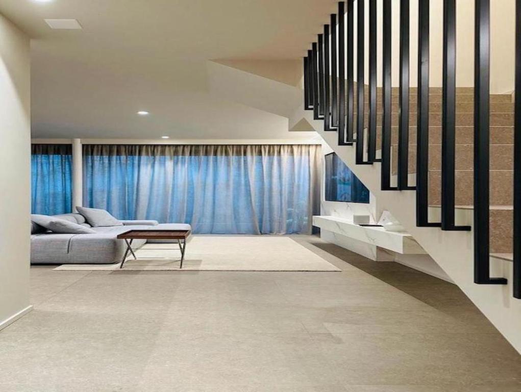 salon z kanapą i schodami w obiekcie Appartamento di lusso su 2 livelli con mini piscina esterna a 5 min da Tasis w mieście Montagnola