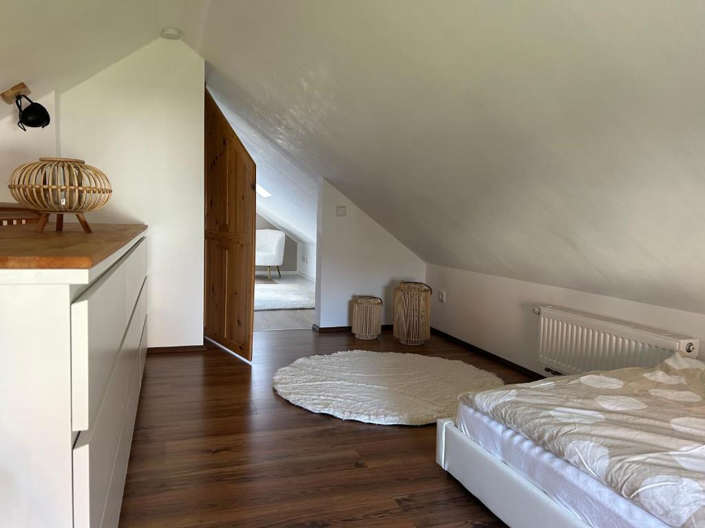 a white room with a bed and a wooden floor at stylisches Ferienhäuschen in Güstrow