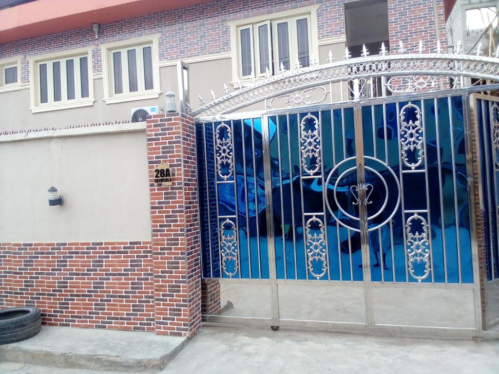 a gate to a house with blue glass at Kemi hotel in Ikeja