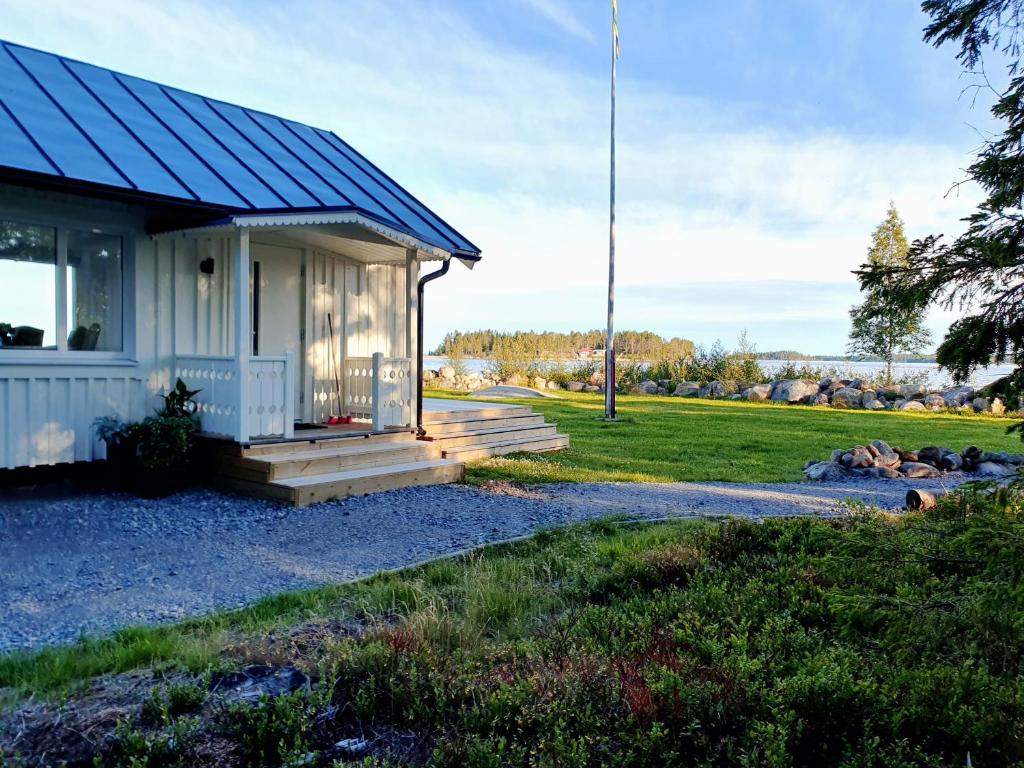 Robertsfors的住宿－Stuga med havsutsikt，蓝色屋顶的白色小房子