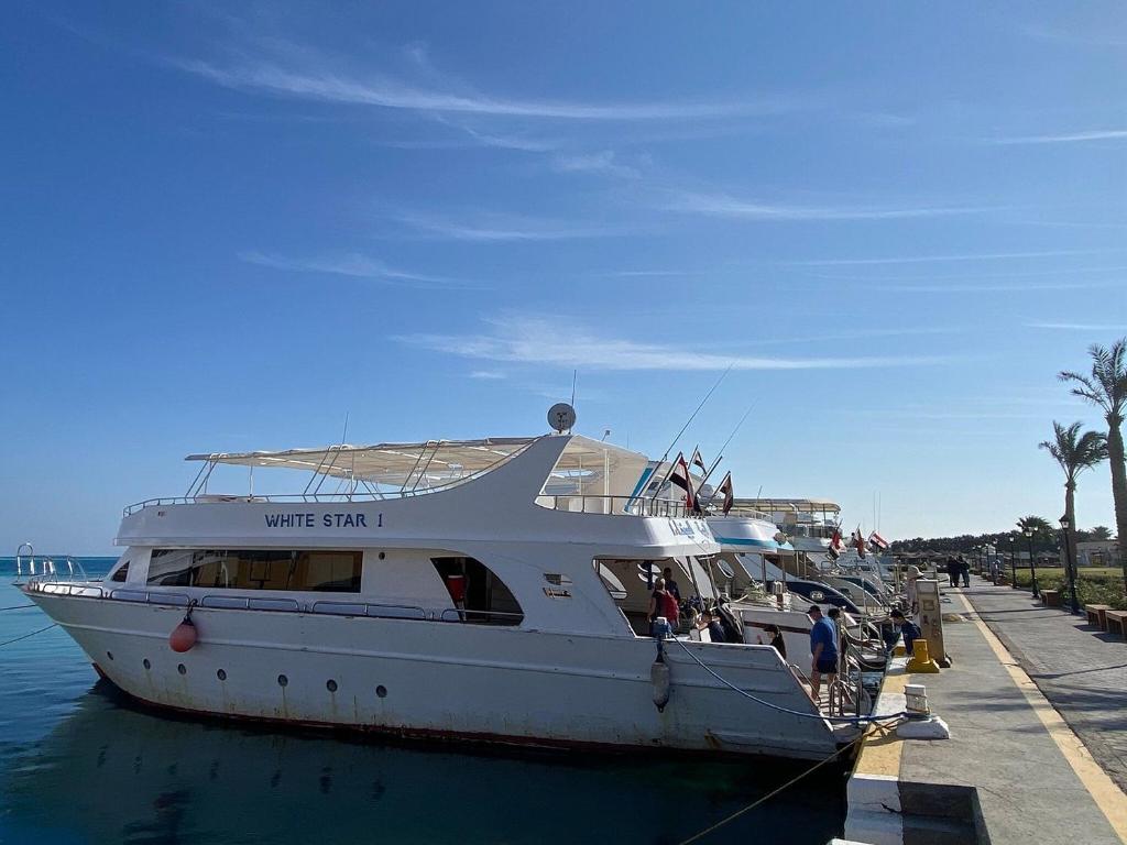 a white boat is docked at a dock at Hurghada Tours in Hurghada