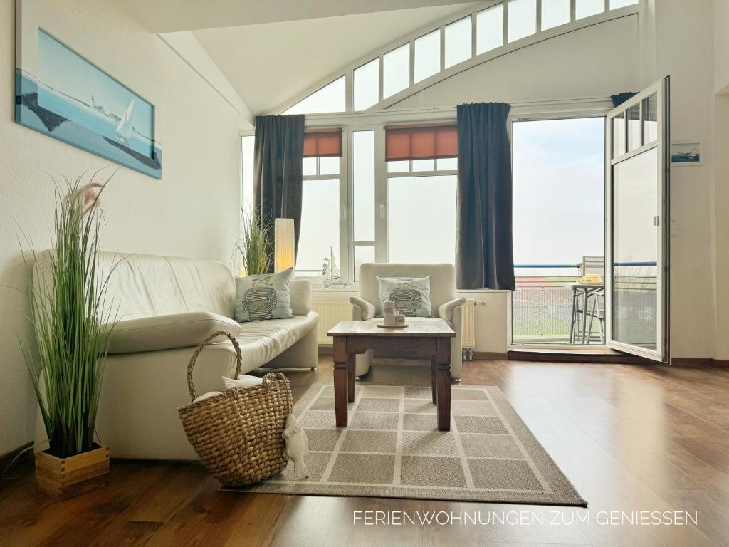 a living room with a couch and a table at Ferienwohnung de Uul mit Sauna und Schwimmbad in Dorum Neufeld
