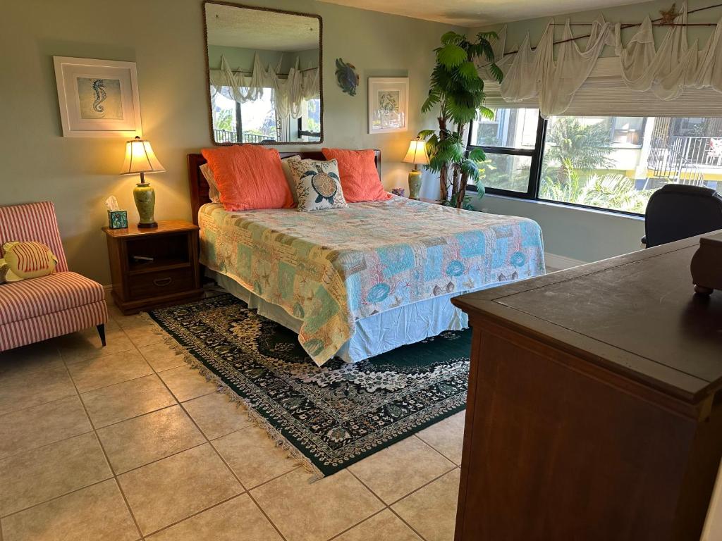 Un dormitorio con una cama, una silla y un espejo. en Beacon reef #204, en Islamorada