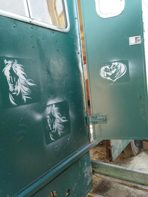 a green door with drawings of horses on it at Charming 1-Bed Cabin in oving in Chichester