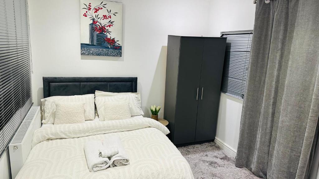 a bedroom with a bed and a black cabinet at COSY AND COMFY DOUBLE ROOM in London