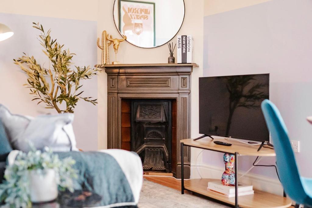 a living room with a fireplace and a tv at Cosy & Stylish London Apartment in London