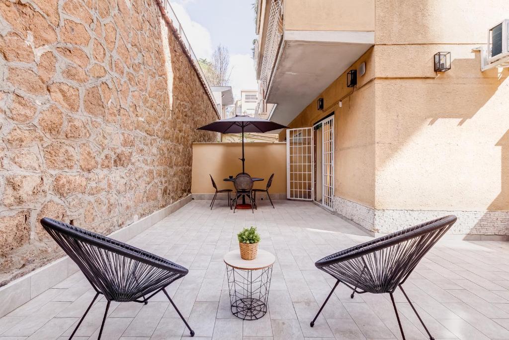 a patio with two chairs and a table with an umbrella at Aventino Industrial Loft in Rome