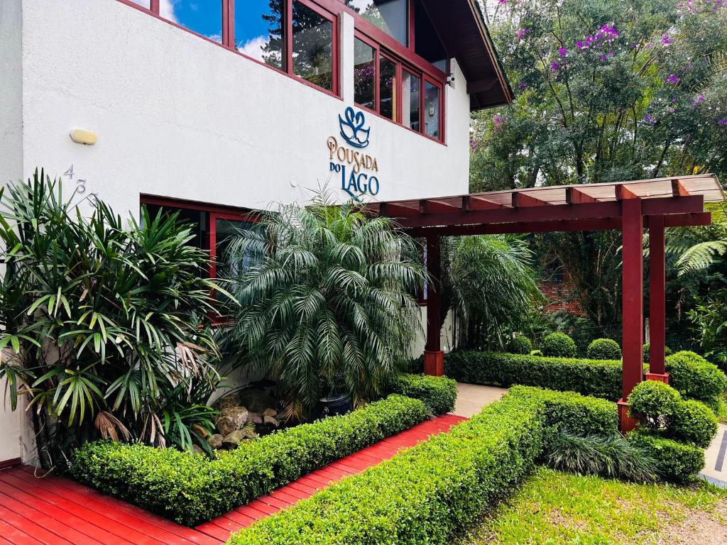 a building with a red walkway in front of it at Pousada do Lago in Gramado