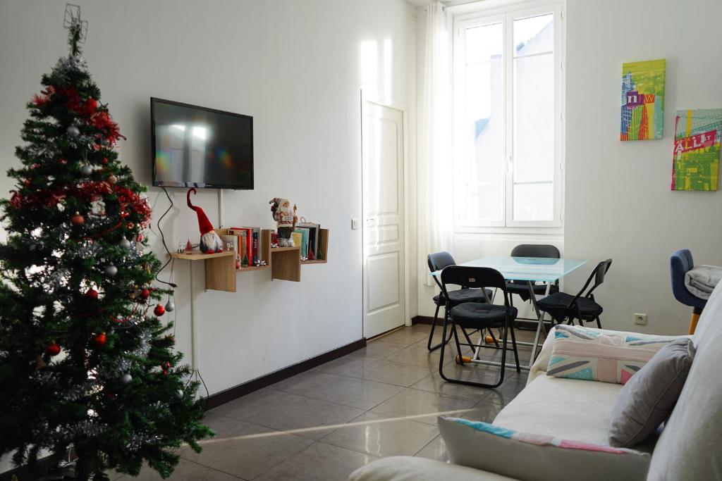 uma sala de estar com uma árvore de Natal e uma mesa em Appartement Nice le Port em Nice