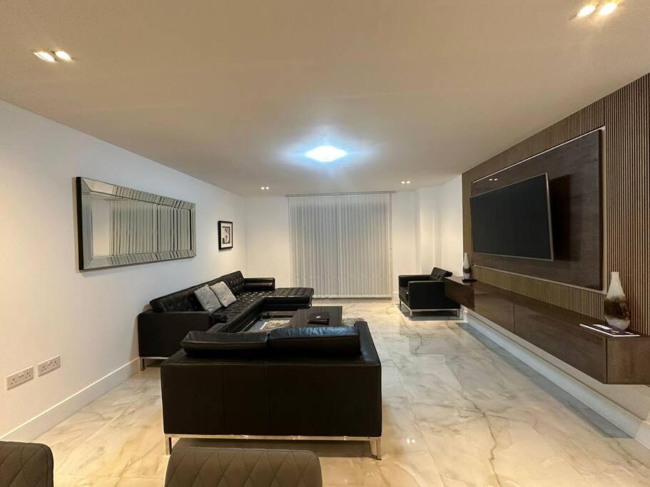 a living room with a couch and a flat screen tv at 3 bed apartment near CanaryWharf in London