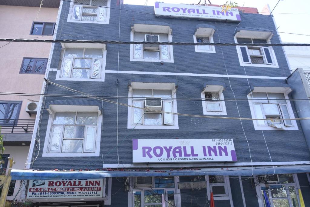 een hoog blauw gebouw met borden erop bij Hotel Royal Inn in New Delhi