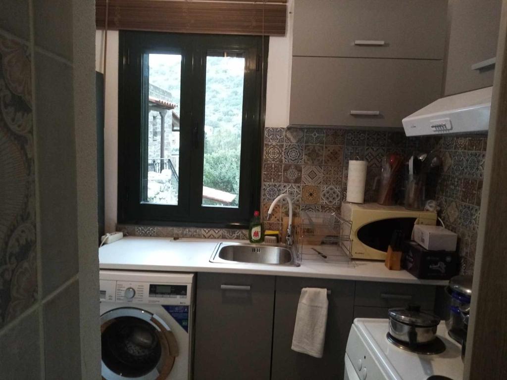 a kitchen with a sink and a washing machine at Family house near the sea in Kokkala