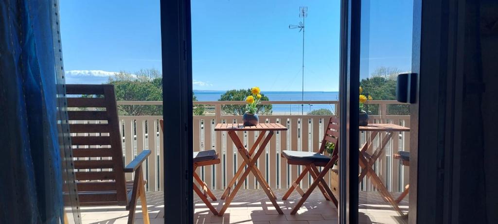 a view of a balcony with a table and chairs at Seaview Beach Front Grado Pineta Andromeda in Grado-Pineta