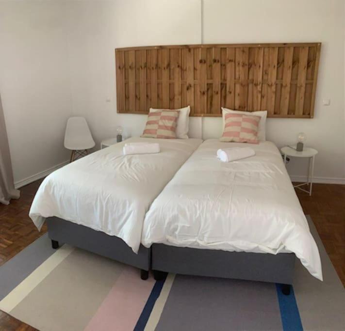 1 dormitorio con 1 cama grande y cabecero de madera en Carcavelos Maristas BEACH pax5, en Carcavelos