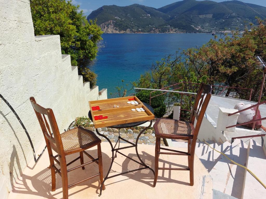 a table and two chairs on a balcony with a view of the water at Maeiz Skopelos in Skopelos Town