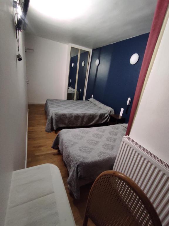 パリにあるホテル ドゥ ナントのベッド2台と椅子が備わる小さな客室です。