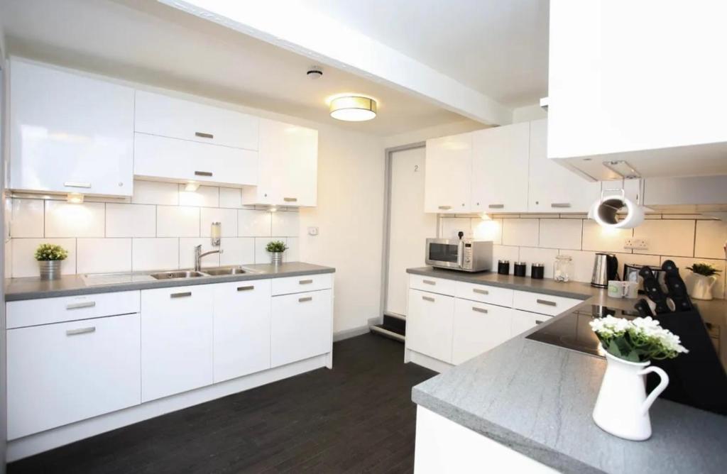 a white kitchen with white cabinets and a sink at New Modern Room With En Suite Park Street Room 2 in Luton