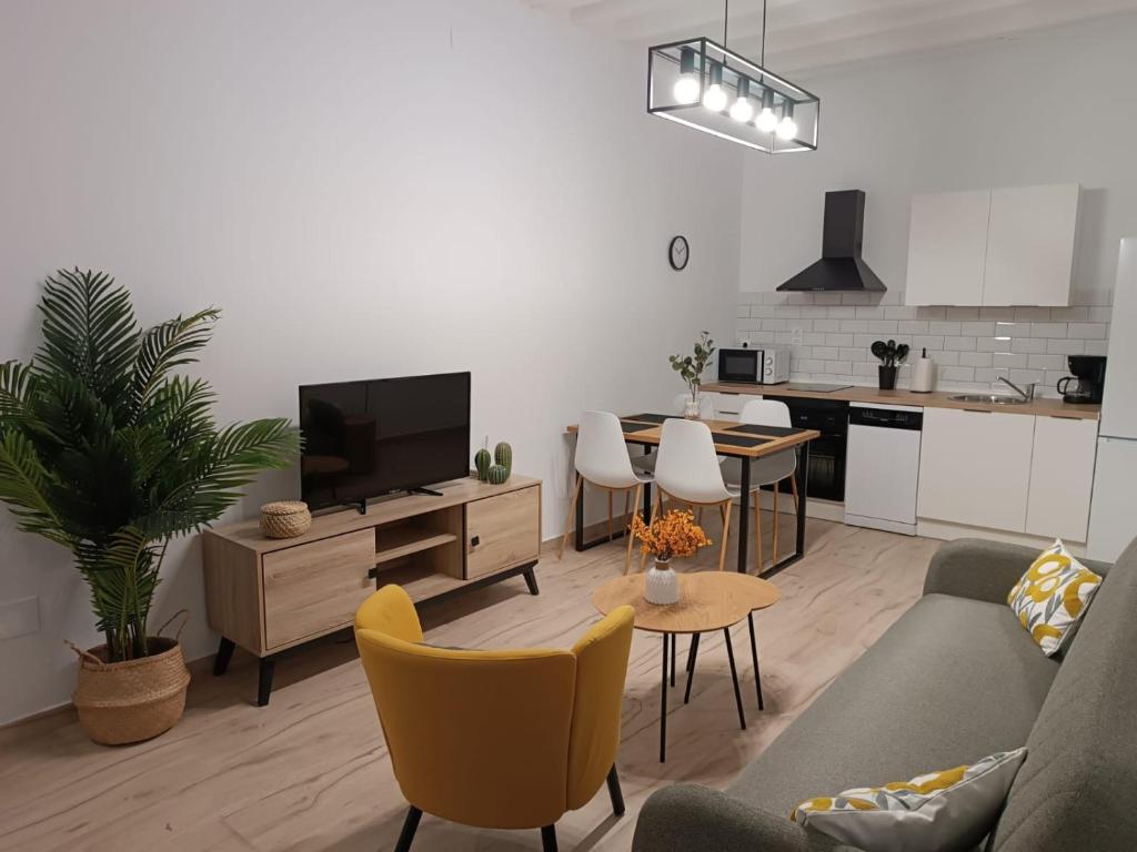 a living room with a couch and a tv and a kitchen at CASA VENERA in Orgaz