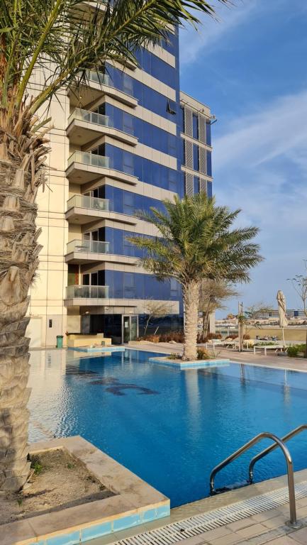 a hotel with a swimming pool in front of a building at Beachfront SeaView Home in Lusail