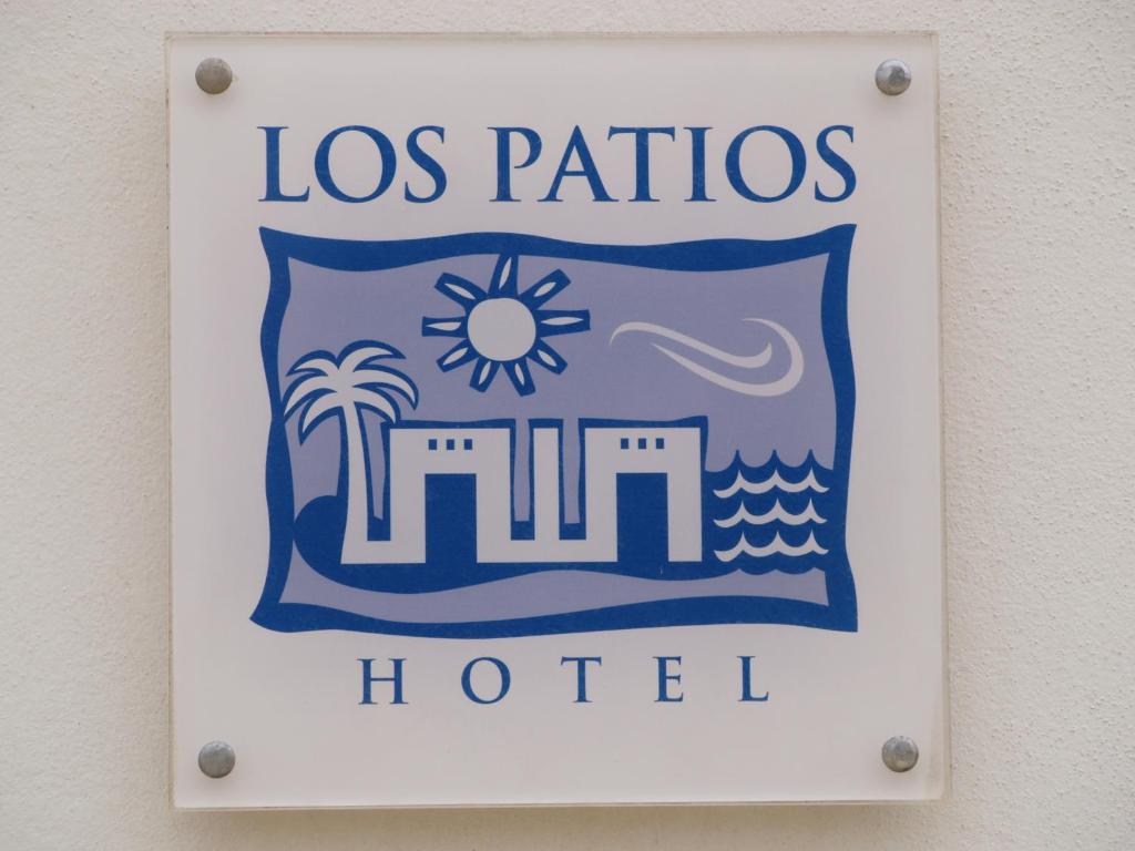 ein Schild für ein Hotel in Los Patos, das an einer Wand hängt in der Unterkunft Hotel Los Patios - Parque Natural in Rodalquilar