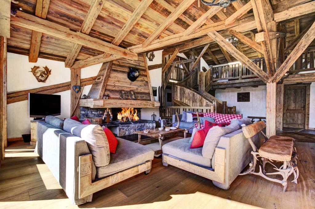 un salon avec deux canapés et une cheminée dans l'établissement Résidence La Ferme De Marie - Chalet 