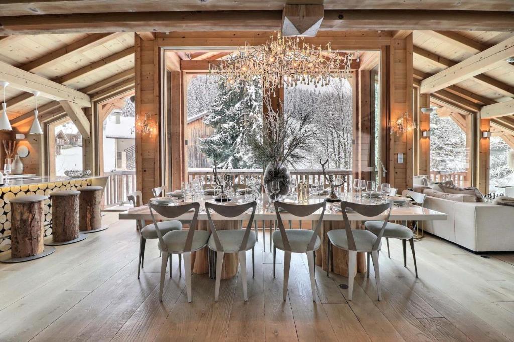 une salle à manger avec une table, des chaises et un lustre dans l'établissement Résidence Explorer Meleze - Chalet Mélèze - 14 Personnes - Les Gets MAE-3801, aux Gets
