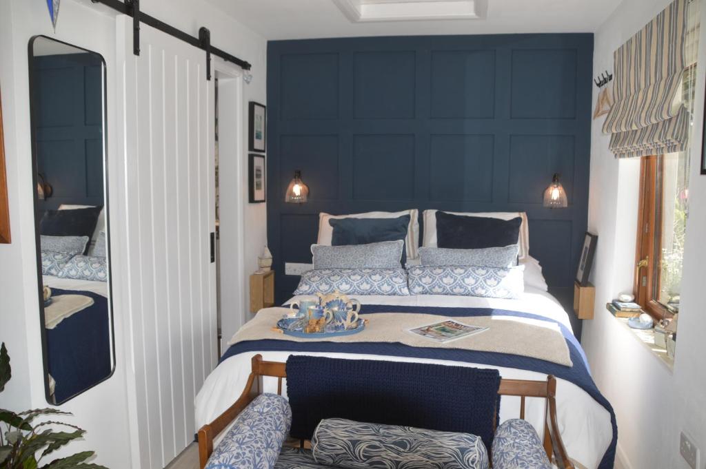 a bedroom with a large bed with a blue headboard at Ropewalk Cottage - A Little Treasure By The Coast in Portaferry