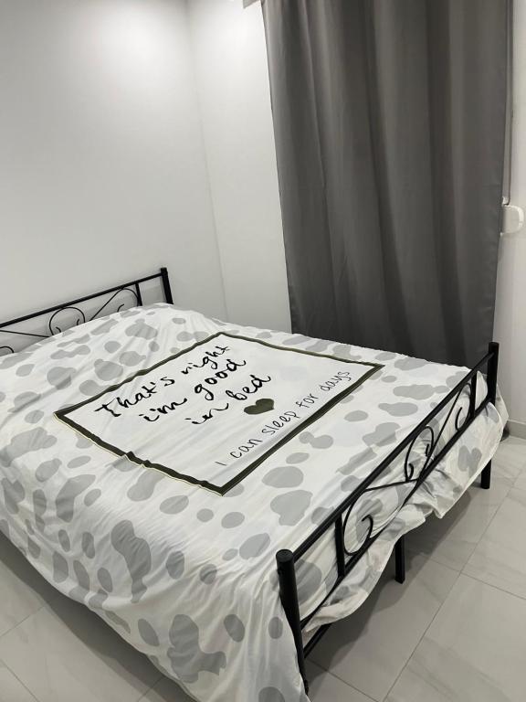 a bed with a sheet with a sign on it at Appartement calme dans villa individuelle in Bagnols-sur-Cèze