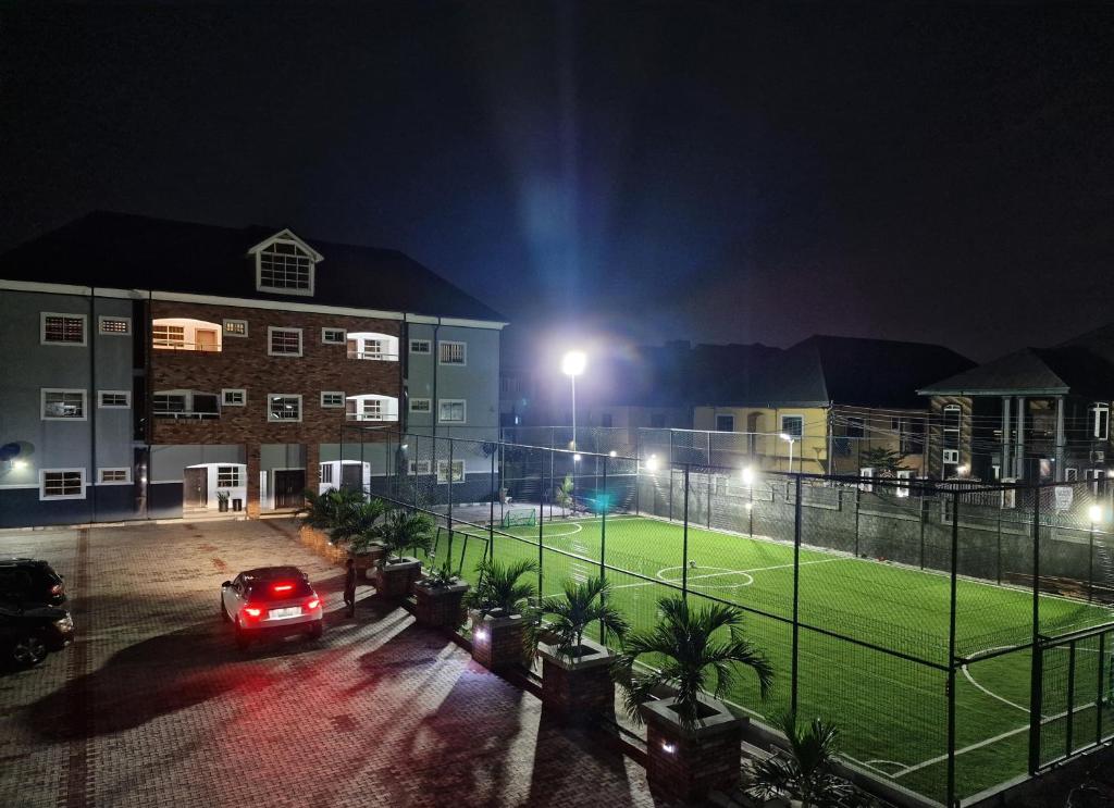 a car driving past a tennis court at night at Schemes Hotel And Apartment in Port Harcourt