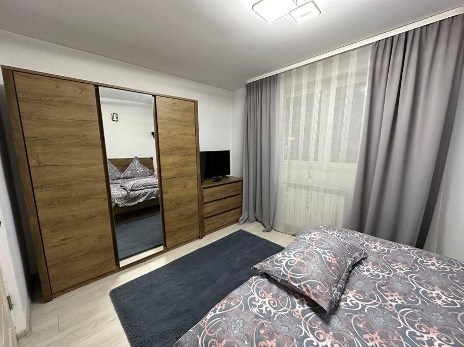 a bedroom with a bed and a large window at Apartament de închiriat in Câmpulung Moldovenesc