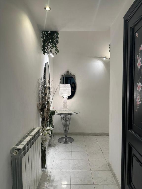 een hal met een tafel en een lamp aan een muur bij La casetta di Roby in Rome