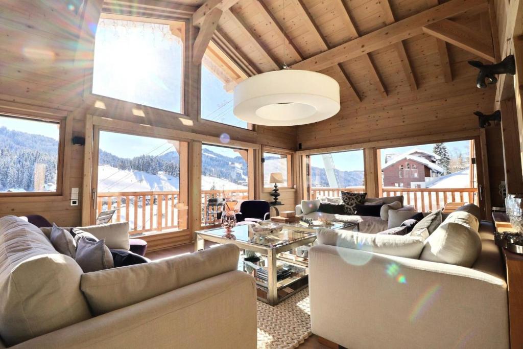 a living room with couches and a table and windows at Résidence Oscar - Chalet Oscar - 12 Personnes - Les Gets MAE-3871 in Les Gets