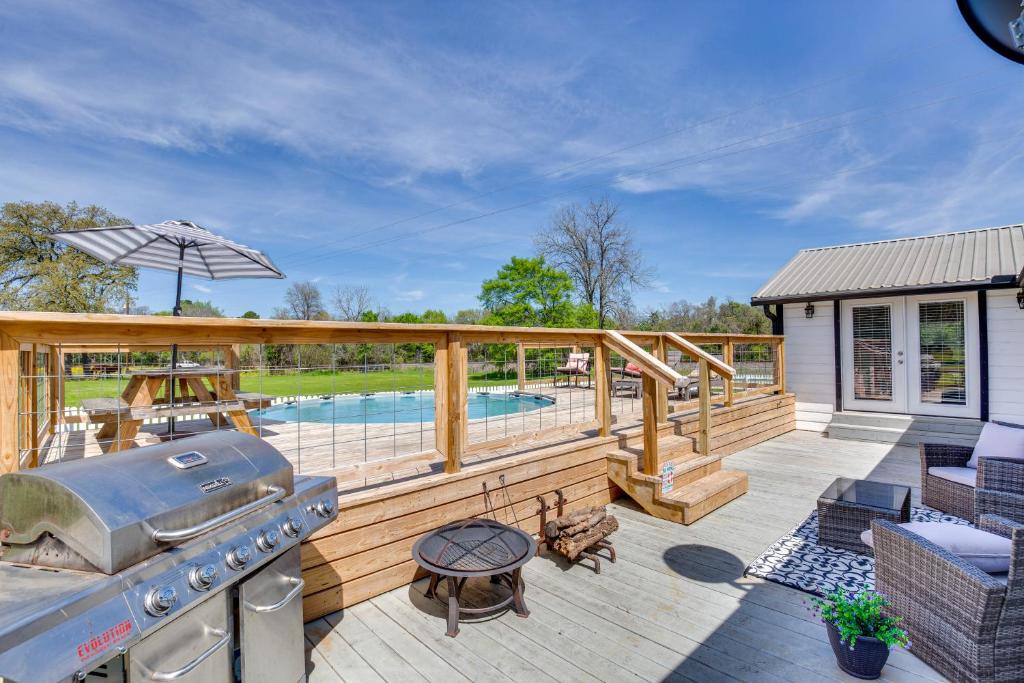 een terras met een grill en een zwembad bij Grapeland Farm Retreat with Pool, Grill and Fire Pit 