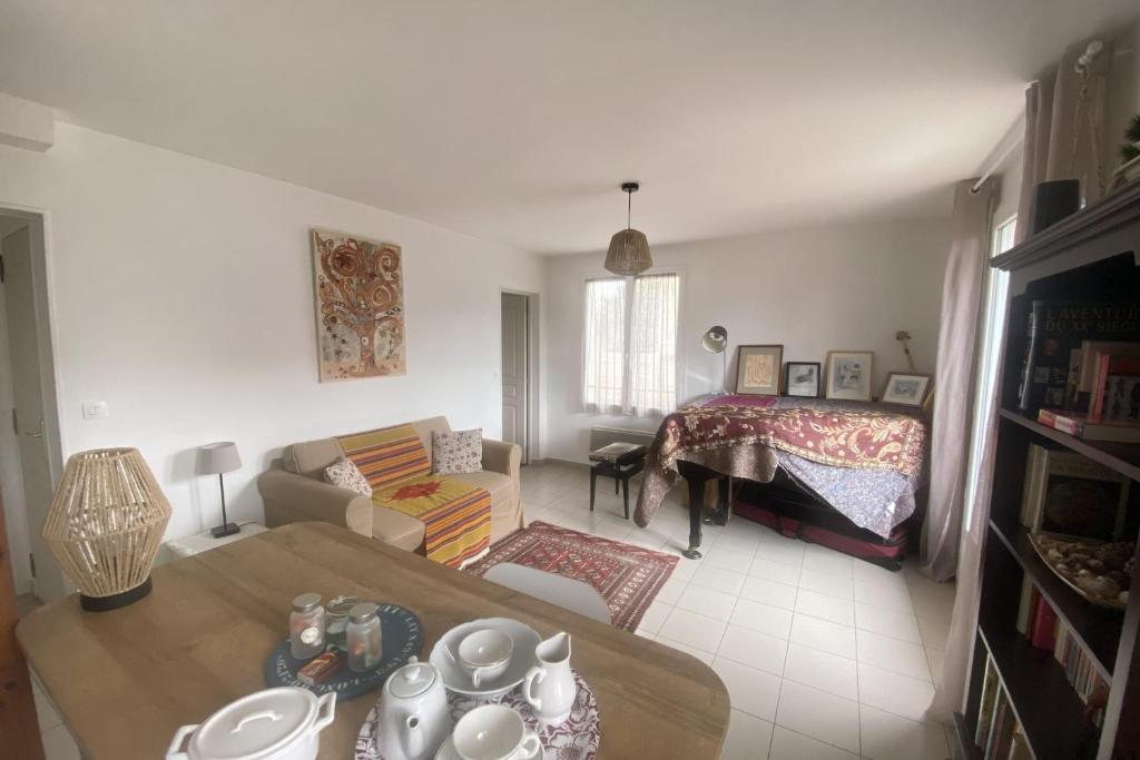 ein Wohnzimmer mit einem Sofa und einem Bett in der Unterkunft Charming house close to the beach in Ouistreham
