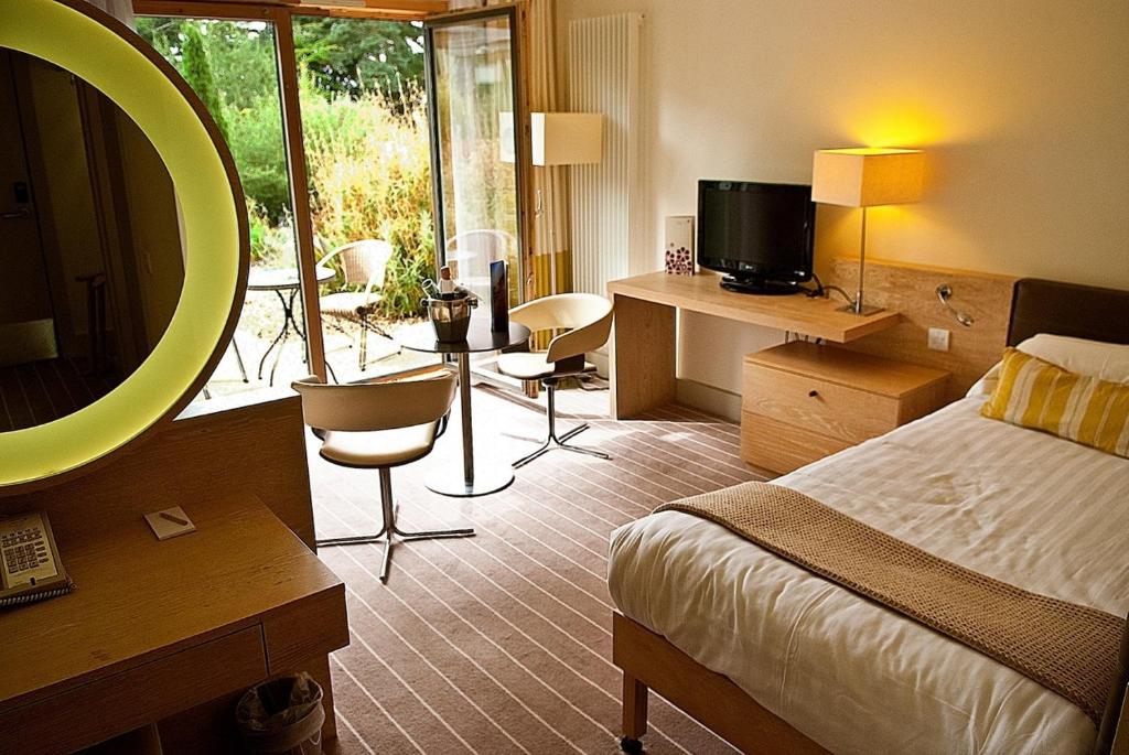 a hotel room with a bed and a mirror at Lifehouse Spa And Hotel in Frinton-on-Sea