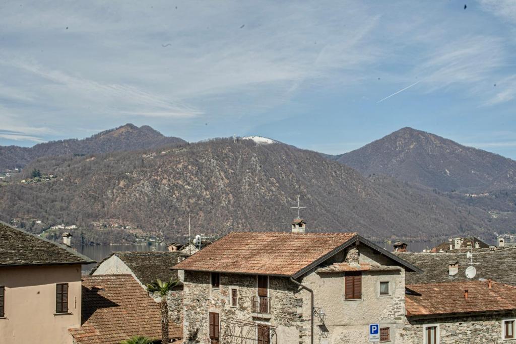 un gruppo di case in una città con montagne sullo sfondo di L&B HOUSE a Orta San Giulio