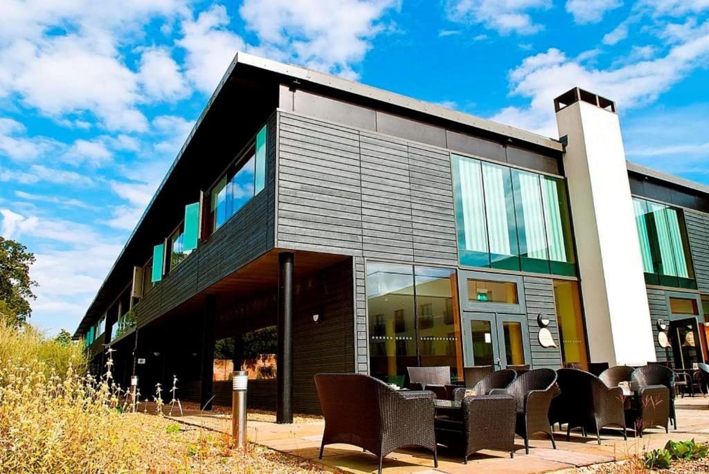 a building with chairs and tables in front of it at Lifehouse Spa And Hotel in Frinton-on-Sea