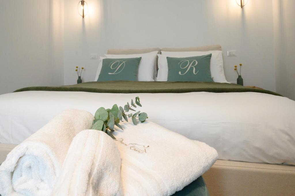 um quarto com uma cama branca com almofadas verdes e brancas em ILLASI DREAM ROOMS em Illasi