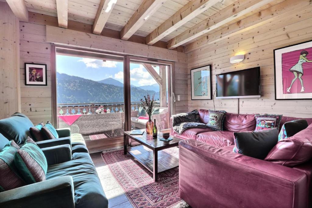 d'un salon avec canapés et télévision ainsi que d'un balcon. dans l'établissement Résidence Les Hauts Forts De La Croix - Appartement Blue Olive - 8 Personnes - Morzine MAE-3981, à Morzine