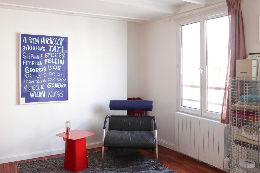 a chair in a room with a chalkboard on the wall at Cosy studio in Paris in Paris