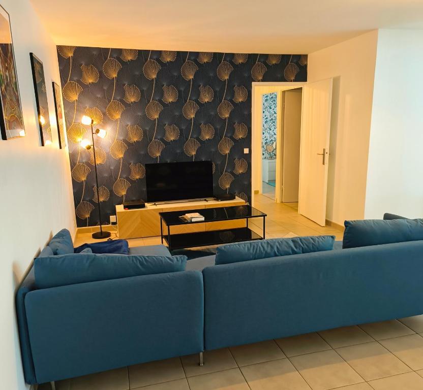 un salon avec un canapé bleu et une télévision dans l'établissement Neuf, calme, 10 minutes du centre de Paris, à Saint-Denis