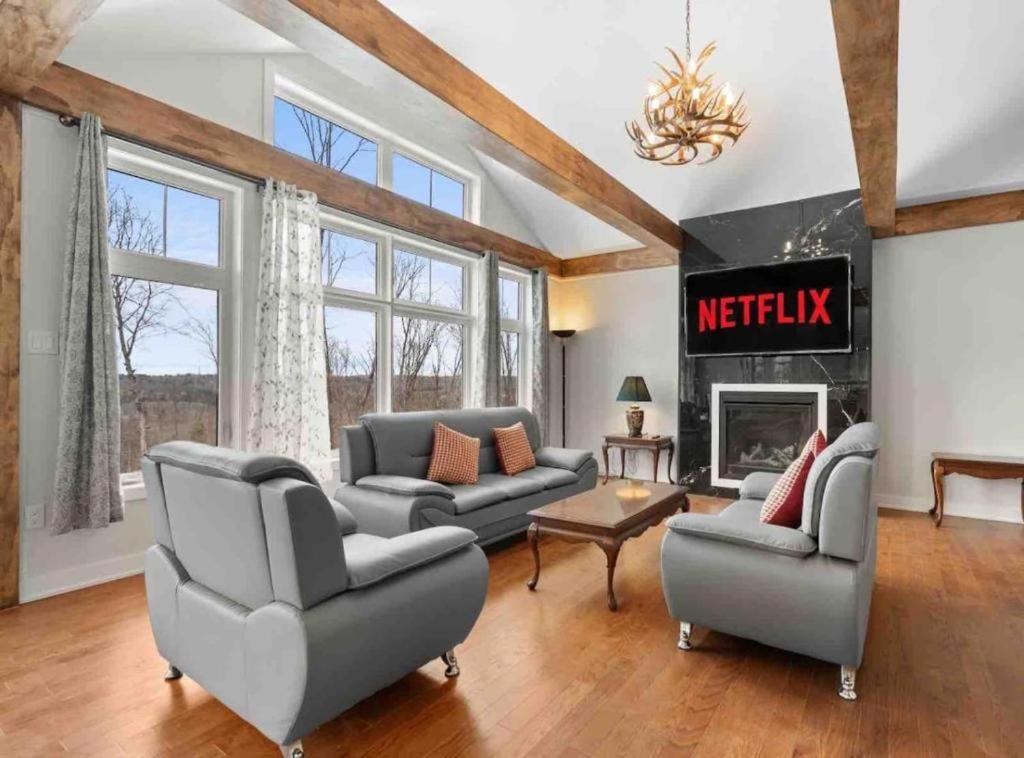 a living room with couches and a fireplace at Muskoka Retreat Stunning Hilltop Views in Huntsville