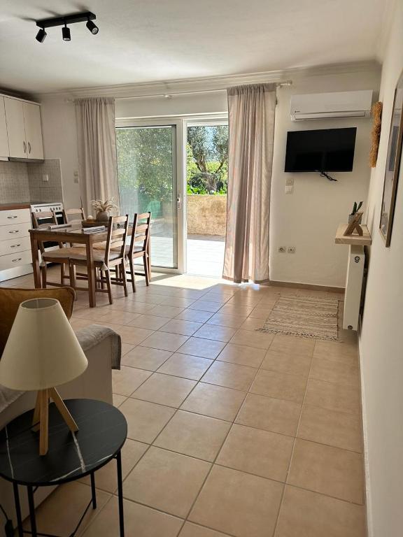 a living room with a kitchen and a dining room at Corfu Lakeside Cottage in Kanoni