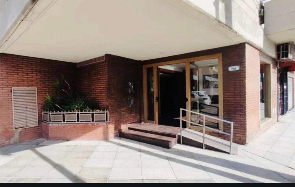 a brick building with a staircase and a glass door at Monoambiente/Studio Avenida Gaona Ramos Mejía in Ramos Mejía