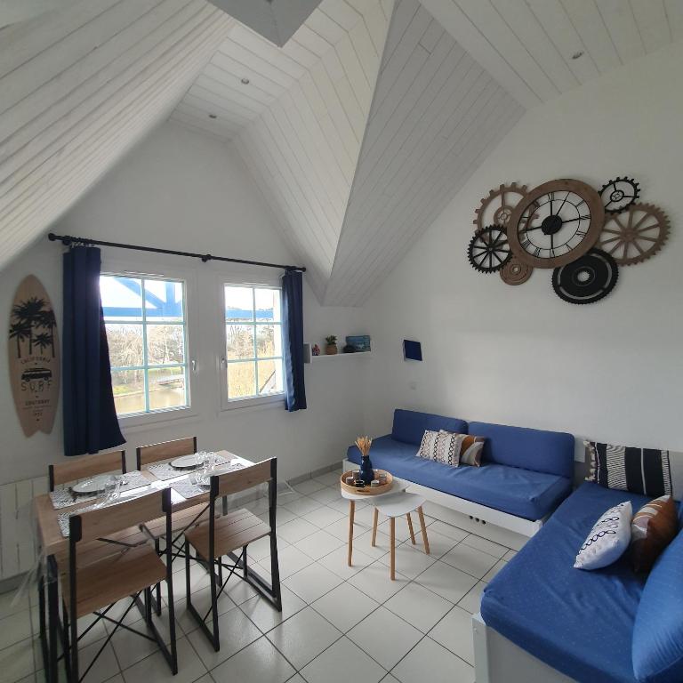 un salon avec un canapé bleu et une table dans l'établissement Appartement à Port Bourgenay, vue sur lac, au pied d'un parc aquatique, à Talmont-Saint-Hilaire