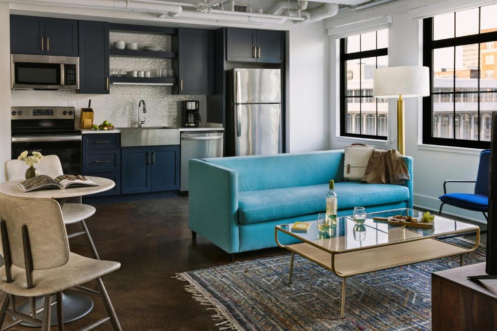 ein Wohnzimmer mit einem blauen Sofa und einem Tisch in der Unterkunft Sonder Dovetail in Nashville