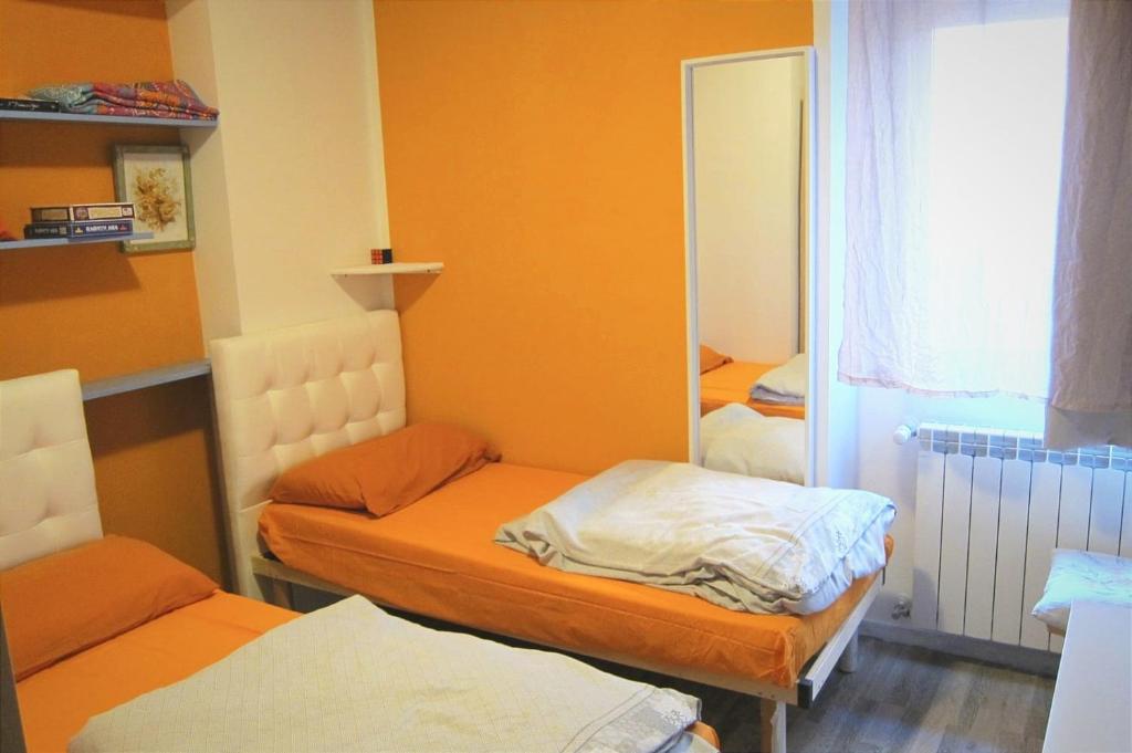 een kleine kamer met 2 bedden en een spiegel bij Camere Stone House in Trieste