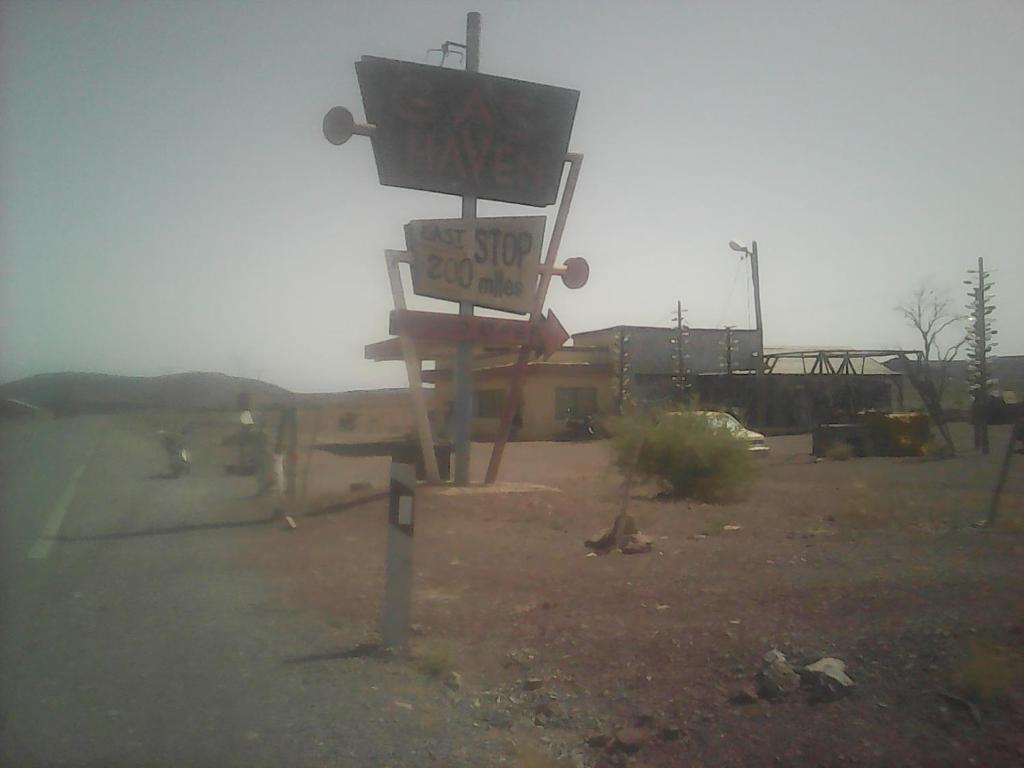 a sign in the middle of a parking lot at Dar adiafa dar asalam in Aït Benhaddou